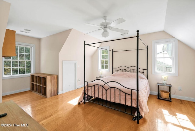 bedroom with light wood-type flooring, lofted ceiling, multiple windows, and ceiling fan