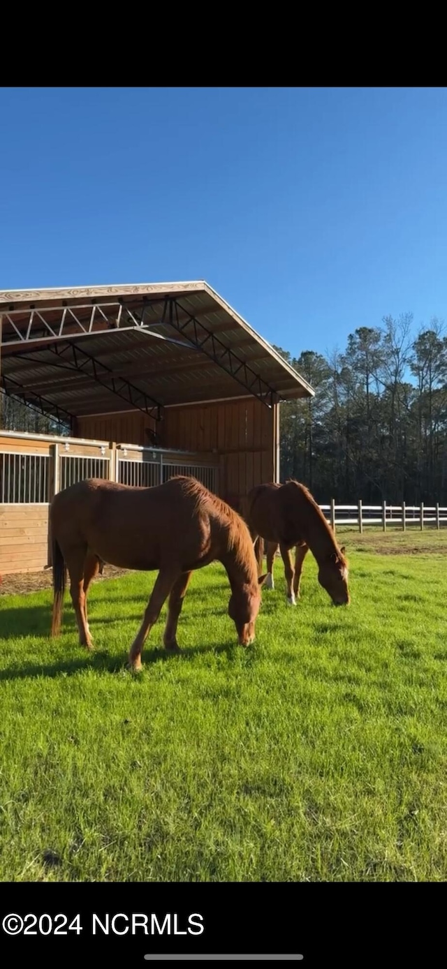 view of horse barn with a rural view