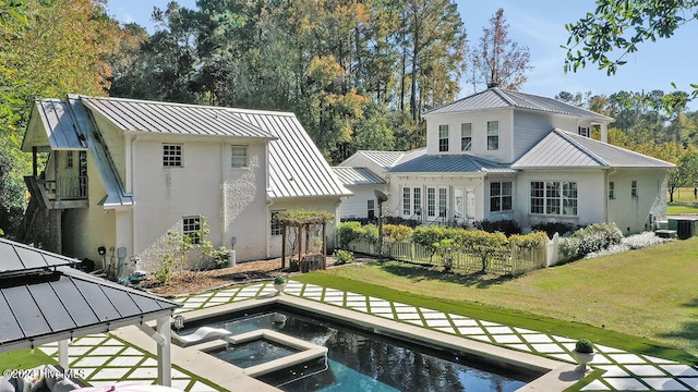 rear view of house with a gazebo, a swimming pool with hot tub, a patio, a yard, and central air condition unit