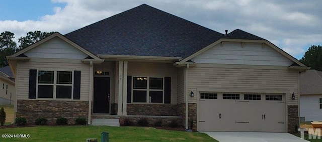 craftsman inspired home featuring a garage and a front lawn