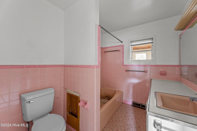 full bathroom featuring vanity, toilet, tile walls, and shower / washtub combination