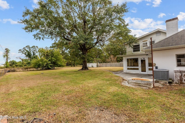 view of yard with central AC unit and a patio