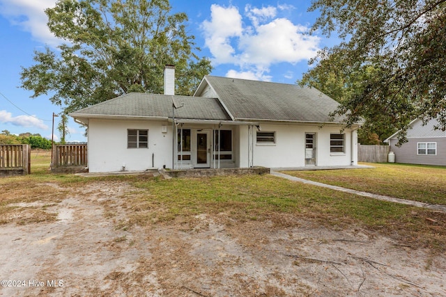 rear view of property with a yard