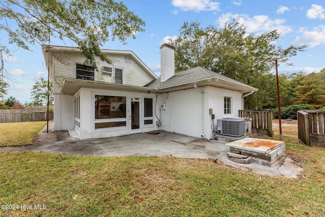 rear view of property featuring a patio, a lawn, and central air condition unit