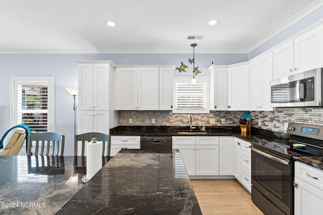 kitchen featuring dark stone countertops, stainless steel appliances, white cabinetry, and pendant lighting