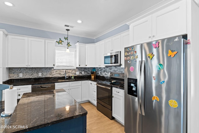 kitchen featuring hanging light fixtures, appliances with stainless steel finishes, white cabinetry, ornamental molding, and sink