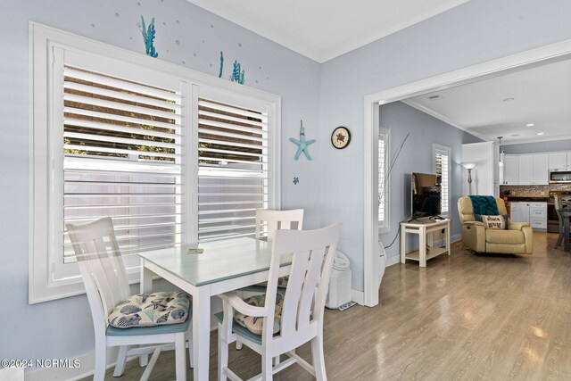 dining room featuring crown molding and light wood-type flooring