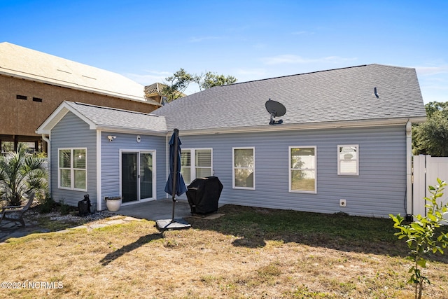 back of property with a yard and a patio