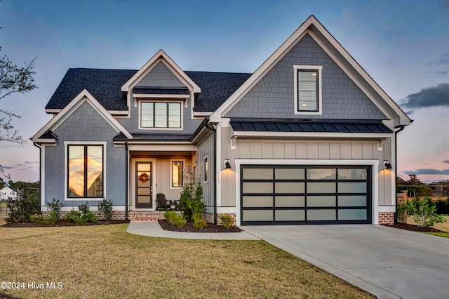 view of front of property with a garage and a lawn