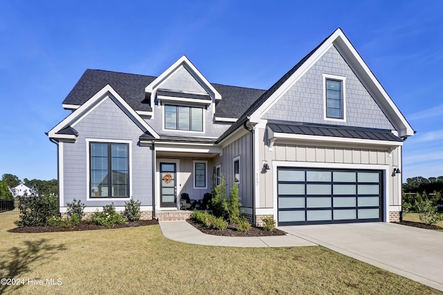 view of front of home featuring driveway, metal roof, a front yard, a garage, and a standing seam roof