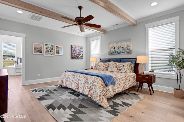 bedroom featuring ceiling fan, multiple windows, and ornamental molding