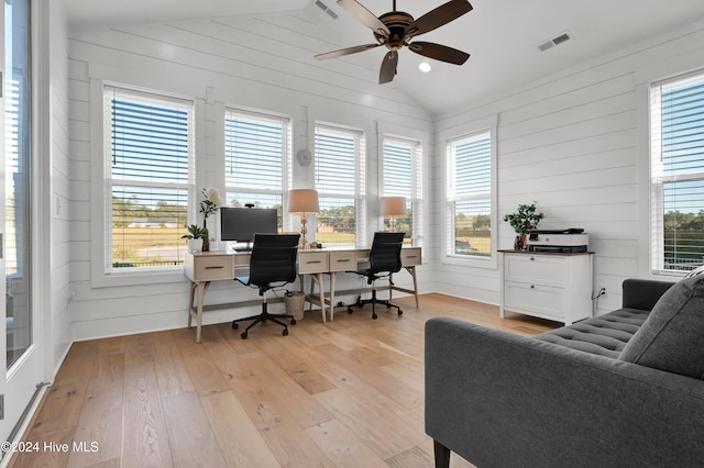 home office with light wood-type flooring, ceiling fan, lofted ceiling, and wooden walls