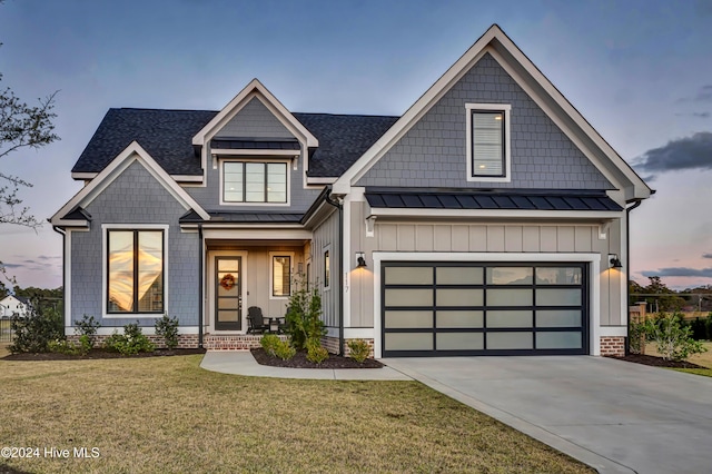 craftsman-style home with roof with shingles, a front lawn, a standing seam roof, driveway, and metal roof