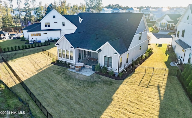 rear view of house with a residential view, roof with shingles, a fenced backyard, board and batten siding, and a patio