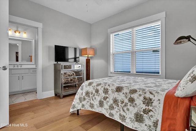 bedroom featuring ensuite bath, ceiling fan, and light hardwood / wood-style flooring