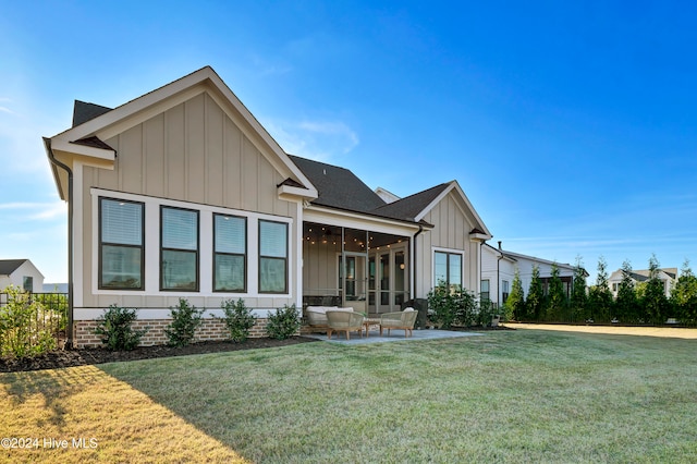 back of house with a patio area, a sunroom, and a yard