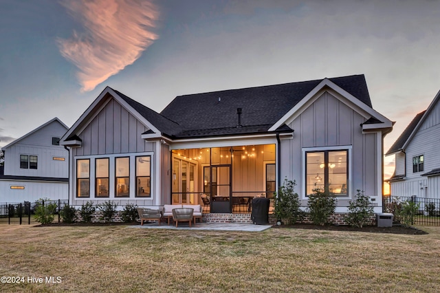 back house at dusk featuring an outdoor hangout area, a yard, and a patio