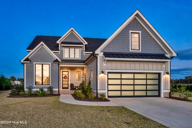 view of front of property featuring a garage and a lawn