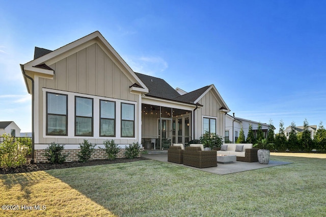 rear view of property featuring an outdoor living space, a sunroom, a lawn, and a patio