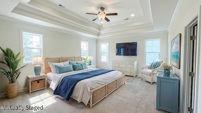 carpeted bedroom with ceiling fan, crown molding, multiple windows, and a tray ceiling