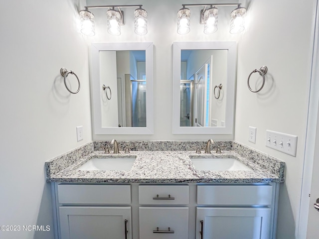 bathroom with vanity and a shower with door