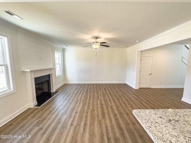 unfurnished living room with hardwood / wood-style flooring, ceiling fan, and crown molding