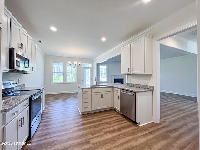 kitchen with white cabinetry, sink, kitchen peninsula, and stainless steel appliances