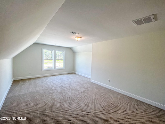 bonus room featuring light colored carpet and vaulted ceiling