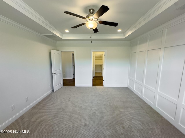 unfurnished bedroom with a tray ceiling, ceiling fan, and ornamental molding