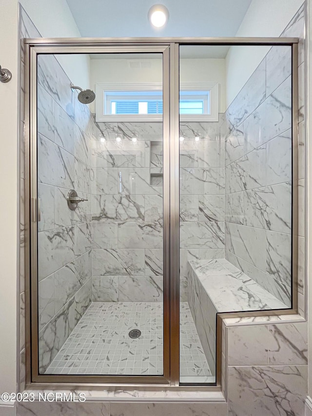 bathroom featuring a shower with shower door