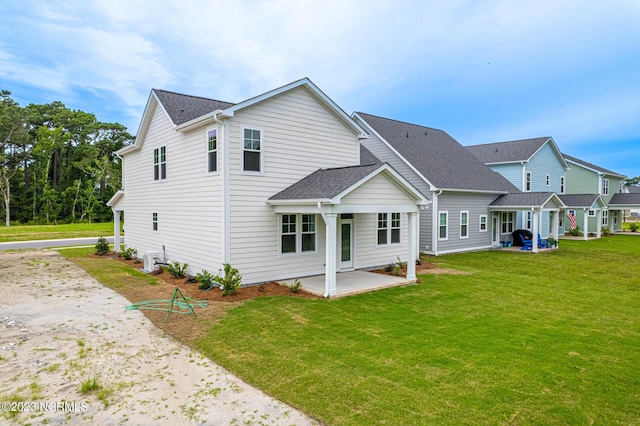 rear view of property featuring a yard and a patio