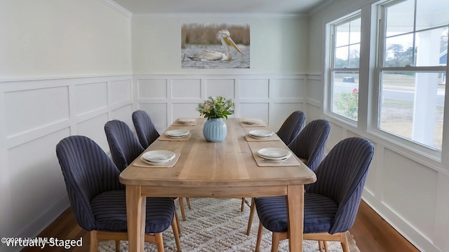 dining space featuring hardwood / wood-style flooring and crown molding