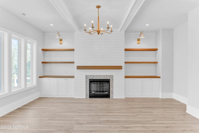 unfurnished living room featuring light hardwood / wood-style floors, beam ceiling, and a wealth of natural light