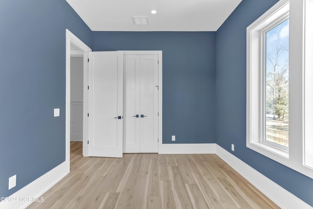 unfurnished bedroom with light hardwood / wood-style flooring and a closet