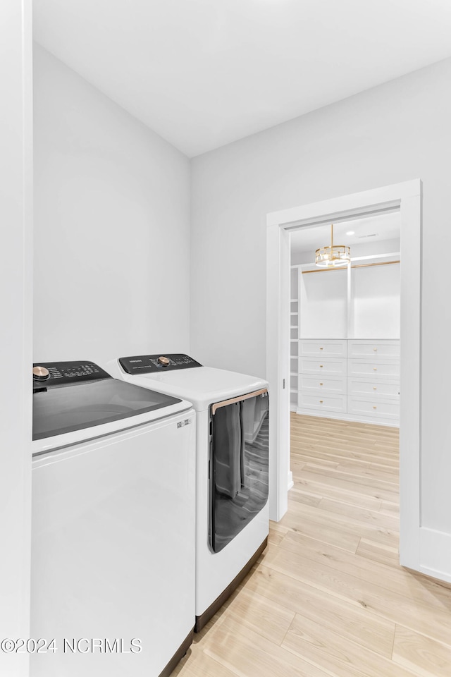 laundry room featuring washer and clothes dryer and light wood-type flooring