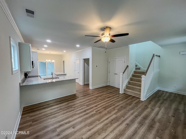 unfurnished living room with ceiling fan with notable chandelier, crown molding, dark hardwood / wood-style flooring, and sink