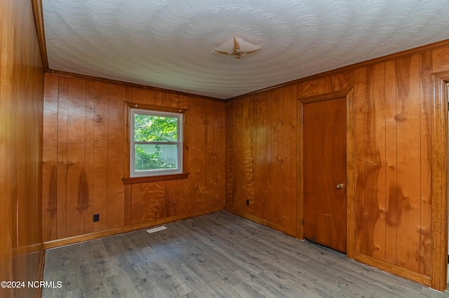 unfurnished room featuring wooden walls and light wood-type flooring