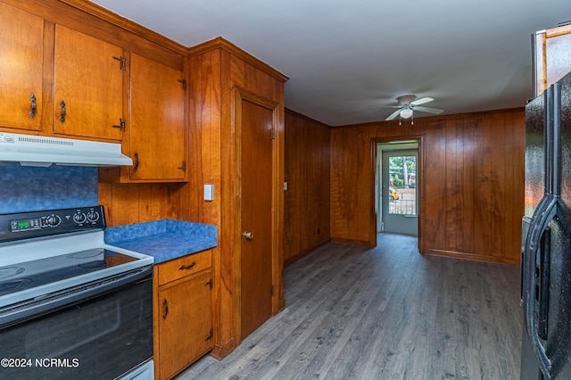 kitchen with black fridge, range with electric cooktop, light hardwood / wood-style flooring, ceiling fan, and wood walls