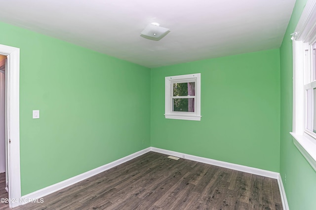 empty room with dark hardwood / wood-style flooring