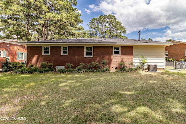 rear view of house featuring a yard and central AC unit