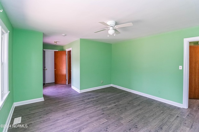 empty room featuring ceiling fan and dark hardwood / wood-style flooring