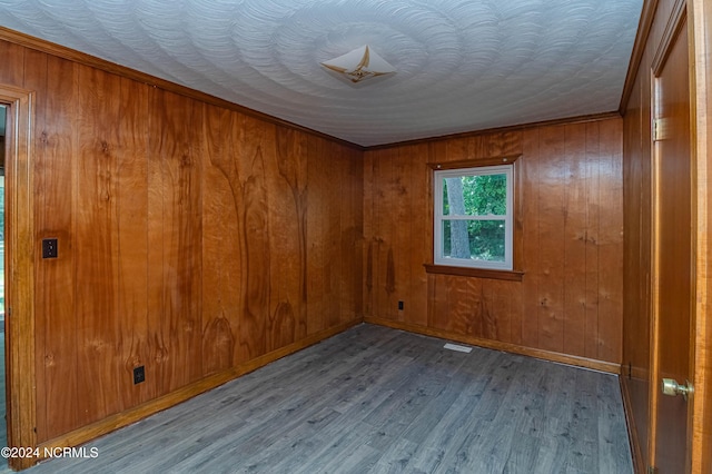 unfurnished room featuring light wood-type flooring and wood walls