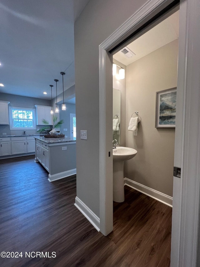 bathroom featuring wood finished floors, visible vents, and baseboards