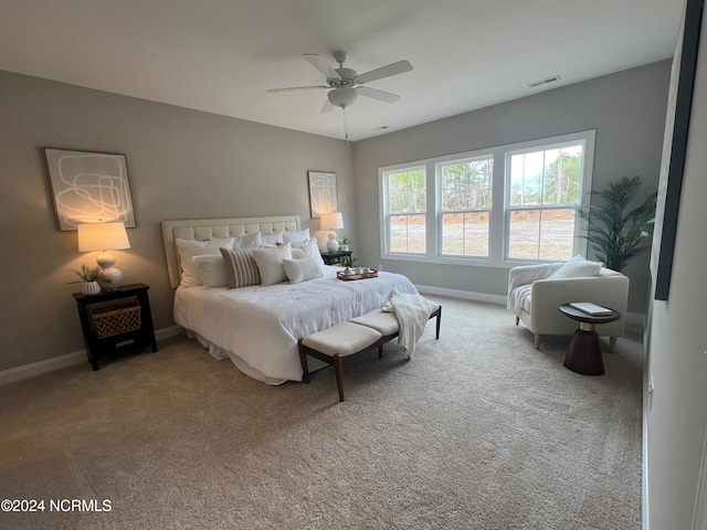 carpeted bedroom featuring baseboards, visible vents, and ceiling fan