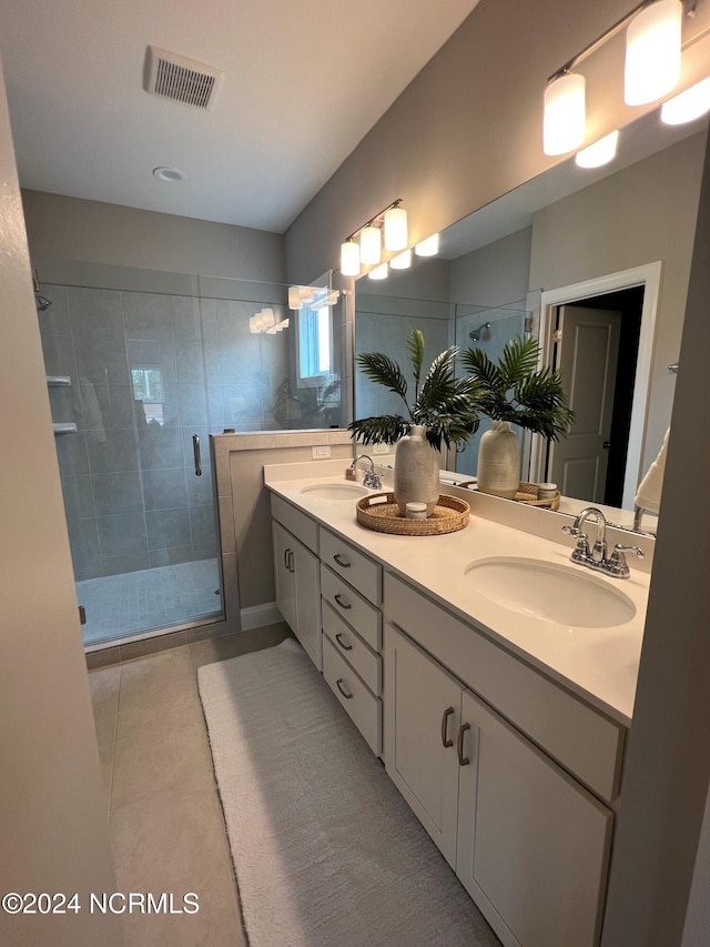 bathroom with a stall shower, visible vents, and a sink