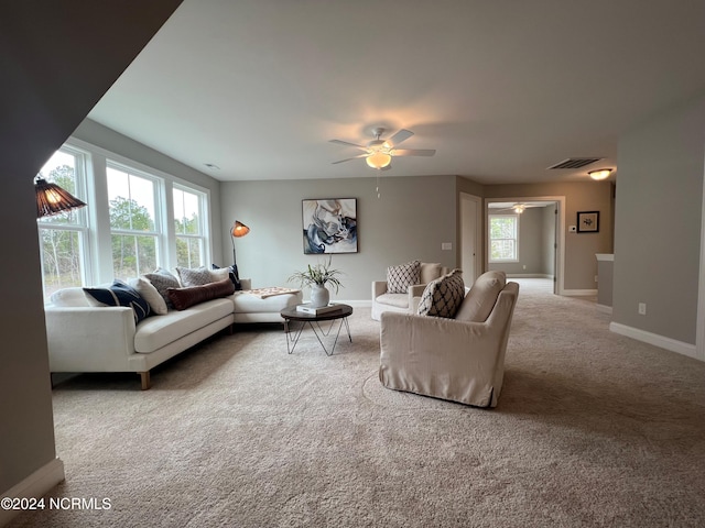 carpeted living room with baseboards, visible vents, and ceiling fan