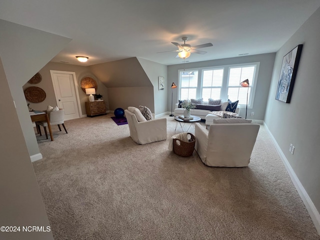 carpeted living area with ceiling fan and baseboards