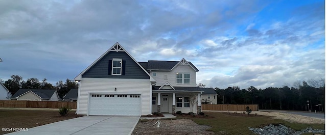 traditional-style house featuring driveway, fence, and a porch