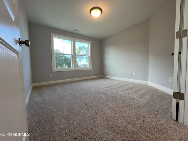 unfurnished room featuring carpet flooring, visible vents, and baseboards