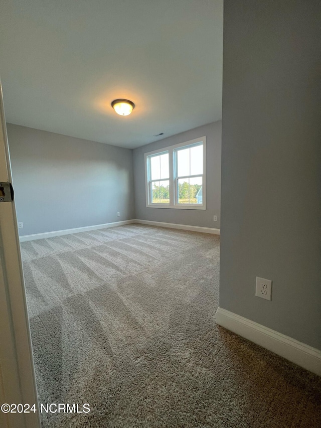 empty room with carpet floors and baseboards